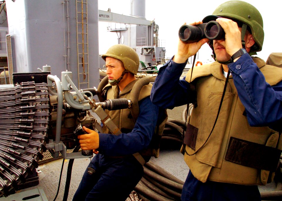 US Navy 090724-N-3925A-010 Gunner's Mate 3rd Class Jonathan Kedzierski, right, and Gunner's Mate 3rd Class Antonio Caron stand watch on the 25mm gun deck aboard the amphibious transport dock ship USS Cleveland (LPD 7)