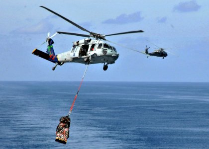 US Navy 090725-N-1644H-118 MH-60S Sea Hawk helicopters from the Island Knights of Helicopter Combat Squadron (HSC) 25 conduct a vertical replenishment between the Military Sealift Command dry-cargo-ammunition ship USNS Alan She