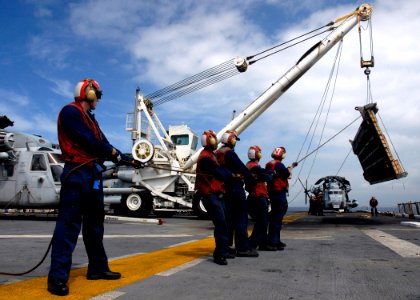 US Navy 090724-N-8283S-213 Sailors assigned to the air department of the amphibious assault ship USS Boxer (LHD 4) hoist a ramp so it can be lifted into its storage area after departing Pearl Harbor