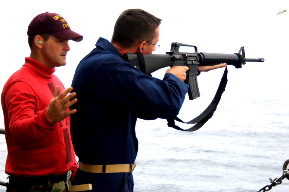US Navy 090726-N-3038W-150 Gunner's Mate 1st Class Sean Reynolds, left, instructs Midshipman 3rd Class Drew Crocker on proper use of an M-16 service rifle during a live-fire exercise on the fantail of the aircraft carrier USS N