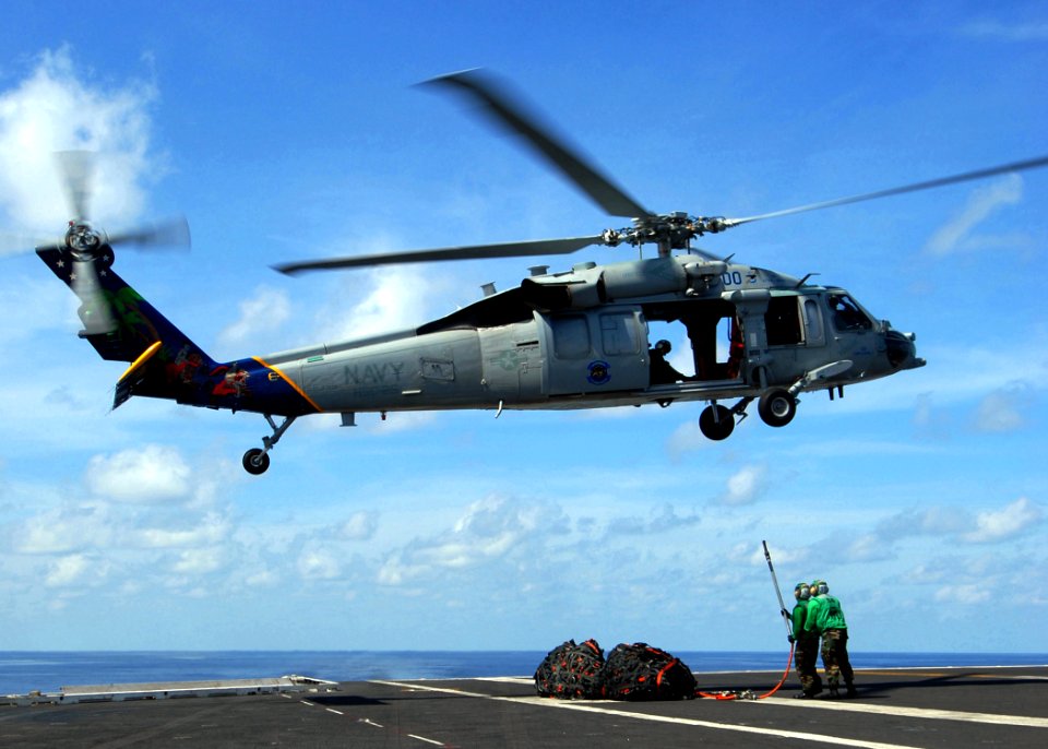 US Navy 090725-N-6720T-011 Sailors assigned to the supply department of the aircraft carrier USS George Washington (CVN 73) attach a cargo net to an MH-60S Sea Hawk helicopter