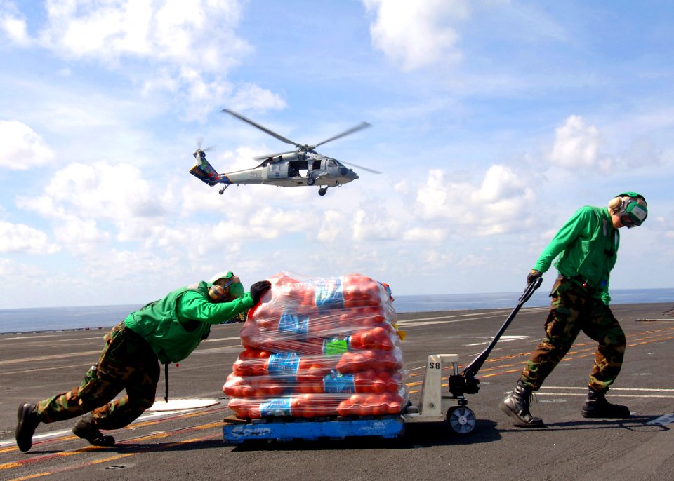 US Navy 090725-N-7282P-046 torekeeper Seaman Matthew King and Storekeeper Seaman Kyle Buchanan, both assigned to the supply department of the aircraft carrier USS George Washington (CVN 73), move stores during a vertical replen