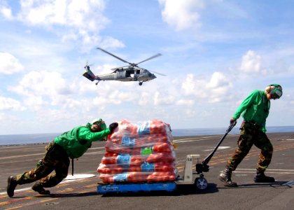 US Navy 090725-N-7282P-046 torekeeper Seaman Matthew King and Storekeeper Seaman Kyle Buchanan, both assigned to the supply department of the aircraft carrier USS George Washington (CVN 73), move stores during a vertical replen