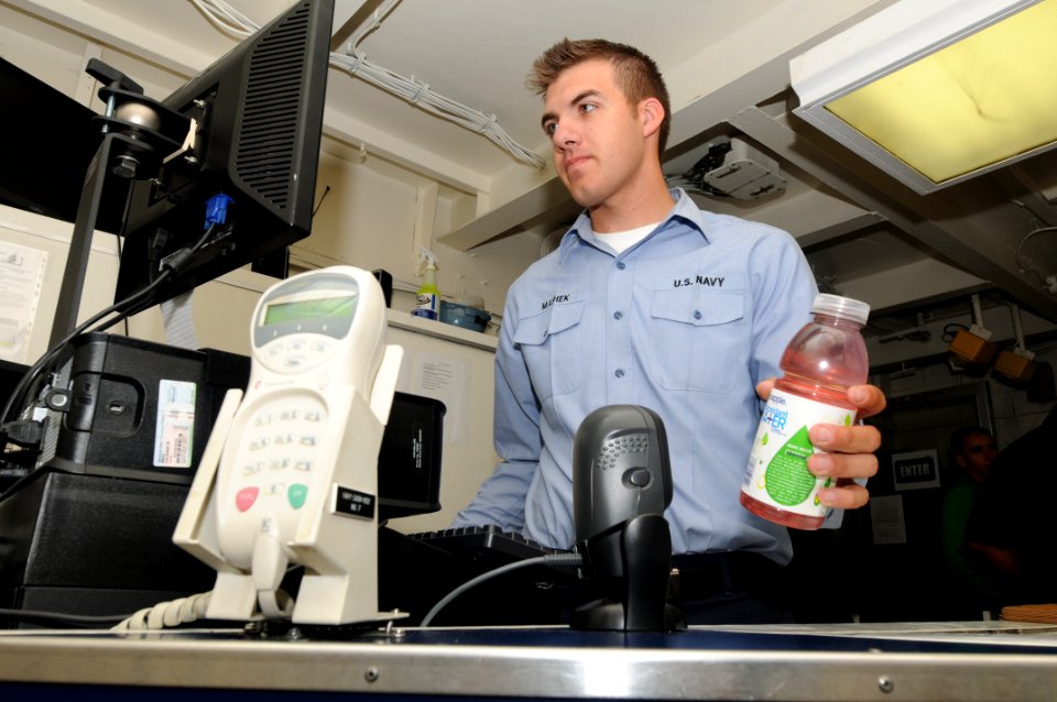 US Navy 090725-N-7456N-058 Ship's Serviceman Seaman Apprentice Robb Mashek rings up a drink for a customer in the Carl Vinson ship's store