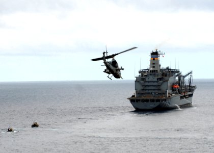US Navy 090730-N-5148B-099 An AH-1W Super Cobra helicopter attached to Marine Medium Helicopter Squadron (HMM) 166 flies over the Military Sealift Command USNS Yukon (T-AO 202)