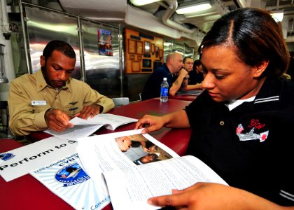 US Navy 090726-N-6233H-024 Chief Navy Counselor Lloyd Stanford, command career counselor for Carrier Air Wing (CVW) 5, explains the Perform to Serve program and conversion packages to Ship's Serviceman Seaman Tia Woodson during