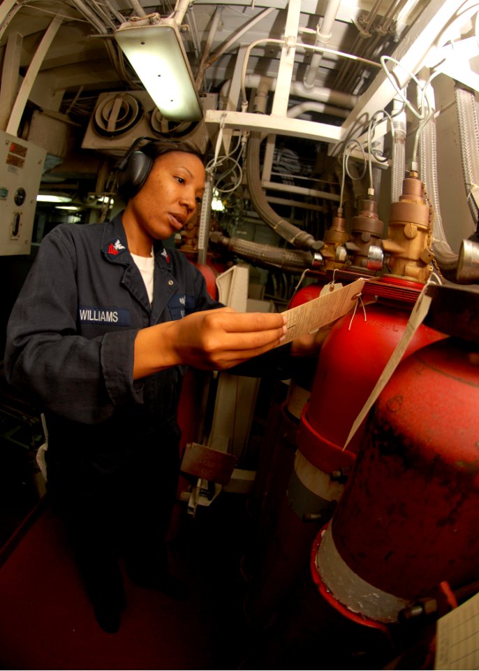 US Navy 090726-N-5148B-080 Damage Controlman 1st Class April Williams, from Oklahoma City, Okla., verifies tags on halon bottles in Main Machinery Room 2 aboard the amphibious dock landing ship USS Rushmore (LSD 47)