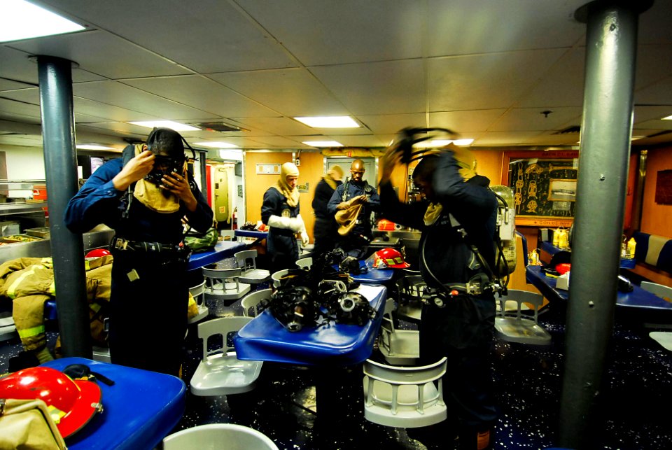 US Navy 090727-N-7092S-267 Sailors assigned to the guided-missile frigate USS Kauffman (FFG 59) don protective gear during a fire drill
