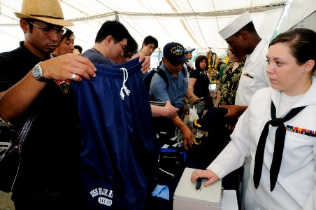 US Navy 090801-N-3830J-194 Ship's Serviceman Seaman Breanne Markey, assign to the amphibious command ship USS Blue Ridge (LCC 19), works the sales table while visitors browse Blue Ridge merchandise