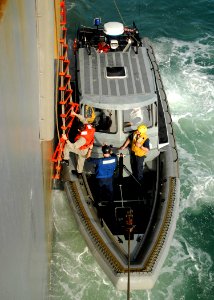 US Navy 090727-N-0924R-017 A Brazilian Sailor climbs down the pilot ladder aboard the amphibious dock landing ship USS Oak Hill (LSD 51) to a ridged hull inflatable boat