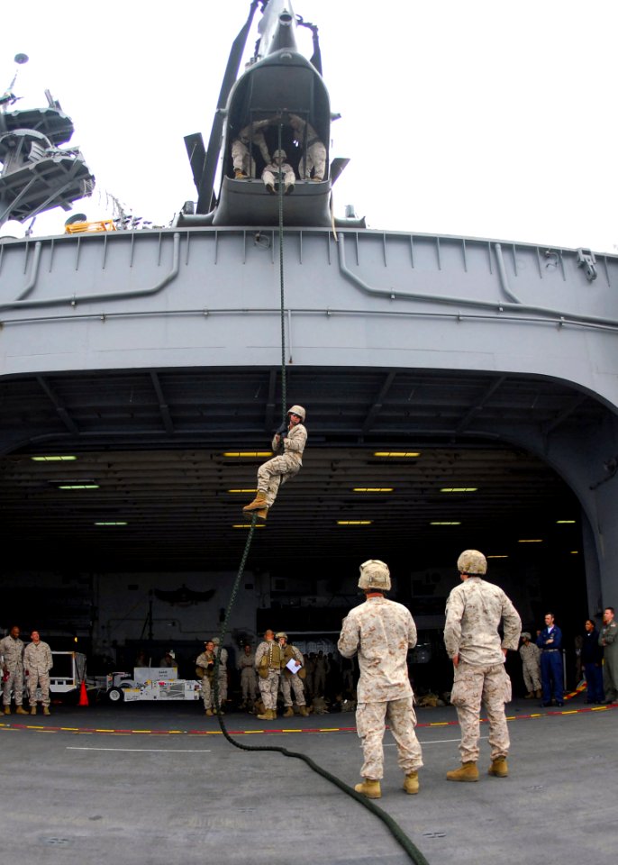 US Navy 090728-N-8607R-199 A U.S. Marine Corps instructor and a hospital corpsman assigned to the 11th Marine Expeditionary Unit (11th MEU) ensure the safety of Marines fast-roping from a static CH-46E Sea Knight helicopter