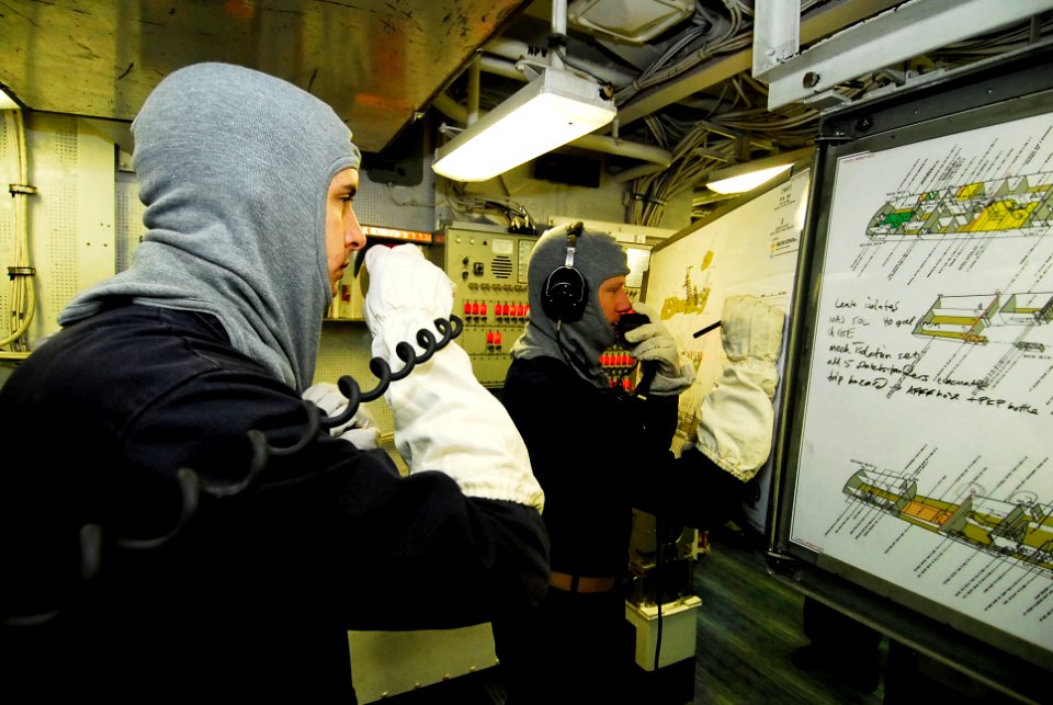 US Navy 090727-N-7092S-398 Lt. j.g. Byron Cody, left, and Ensign Jordan Reagan coordinate damage control efforts during a fire drill aboard the guided-missile frigate USS Kauffman (FFG 59)