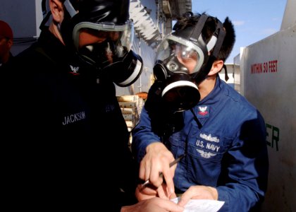 US Navy 090729-N-8534H-070 Ship's Serviceman 2nd Class Francis Manigbas passes instructions to Culinary Specialist 3rd Class Jarryd Jackson during a chemical, biological, or radiological warfare drill