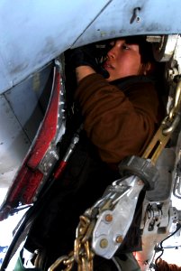 US Navy 090803-N-2600H-003 Aviation Machinist's Mate Airman Apprentice Xiao Wong services the Nitrous Oxide system on an F-A-18 hornet on the flight deck of the aircraft carrier USS Nimitz (CVN 68)