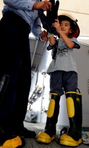 US Navy 090801-N-3830J-195 A child tries on firefighting equipment while aboard the amphibious command ship USS Blue Ridge (LCC 19) during the 33rd annual Friendship Day