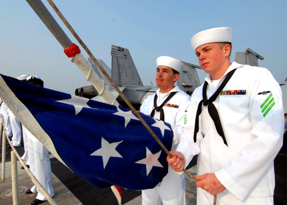 US Navy 090802-N-6720T-030 Aviation Boatswain's Mate (Equipment) Airman Casey Powell, right, and Aviation Boatswain's Mate (Handling) Airman Sonny Baca raise the ensign aboard the aircraft carrier USS George Washington (CVN 73)