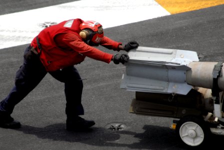 US Navy 090801-N-9132C-194 An Aviation Ordnanceman pushes a guided bomb unit across the flight deck of the aircraft carrier USS Ronald Reagan (CVN 76)