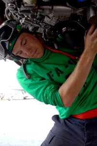 US Navy 090801-N-2918M-012 Aviation Mechanic's Mate 3rd Class Andrew Engle, assigned to the Warhawks of Strike Fighter Squadron (VFA) 97, removes the main fuel control on an F-A-18C Hornet photo