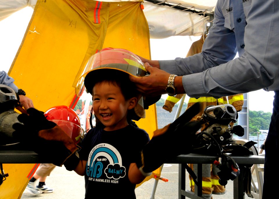 US Navy 090801-N-7478G-131 A child dons a fire helmet aboard the amphibious command ship USS Blue Ridge (LCC 19) during the Commander, Fleet Activities Yokosuka 33rd annual Friendship Day