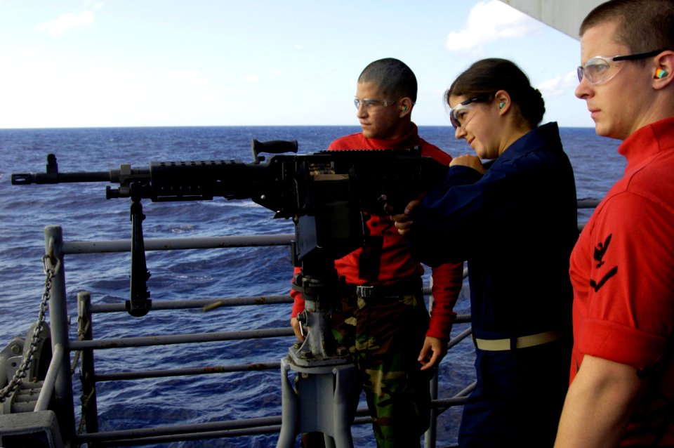 US Navy 090805-N-3038W-412 Gunner's Mate Seaman Sean Tubung and Gunner's Mate 3rd Class Sean Ater look on as Midshipman 3rd Class Michelle Weaver fires am M-240 machine gun