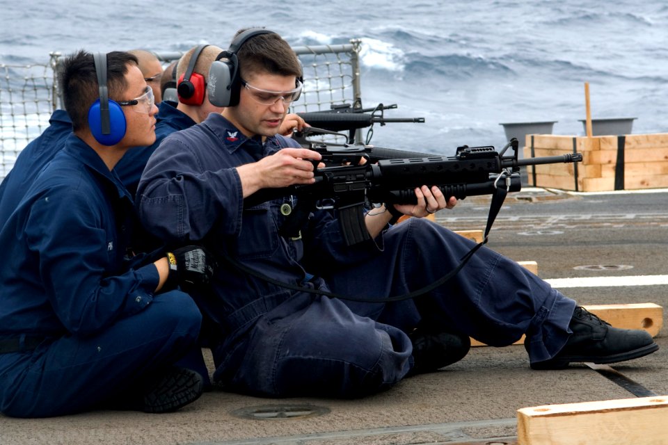 US Navy 090803-N-9123L-012 Fire Controlman 2nd Class Chaung Pha, from Sacramento, Calif., observes as Hull Technician 2nd Class Donipaul Briscoe of West Plains, Mo., adjusts an M-16 service rifle during a small-arms exercise