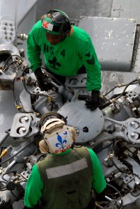 US Navy 090807-N-9132C-175 Aviation Electrician's Mate 1st Class George Cooper, top, instructs a Sailor on maintaining the rotary system of an SH-60F Sea Hawk