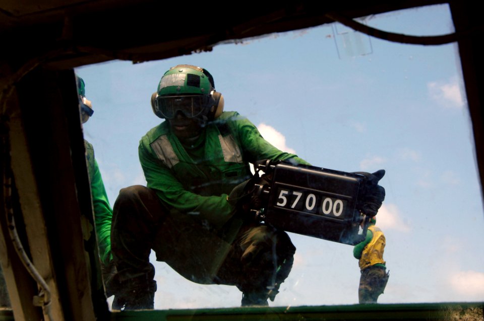 US Navy 090808-N-3038W-008 Weight board operator Aviation Boatswain's Mate (Equipment) Airman Richard Stones shows weight settings to flight deck personnel before launching aircraft from the aircraft carrier USS Nimitz (CVN 68)