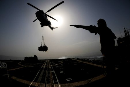 US Navy 090805-N-6814F-269 Seaman Jared Hanschu directs an SA-330 Puma helicopter to drop a pallet onto the flight deck of the guided-missile cruiser USS Anzio (CG 68)