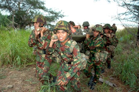 US Navy 090806-N-8539M-205 Royal Brunei Land Force soldiers and U.S. Marines carry a simulated mudslide victim to a field hospital during a Cooperation Afloat Readiness and Training (CARAT) Brunei 2009 humanitarian and disaster
