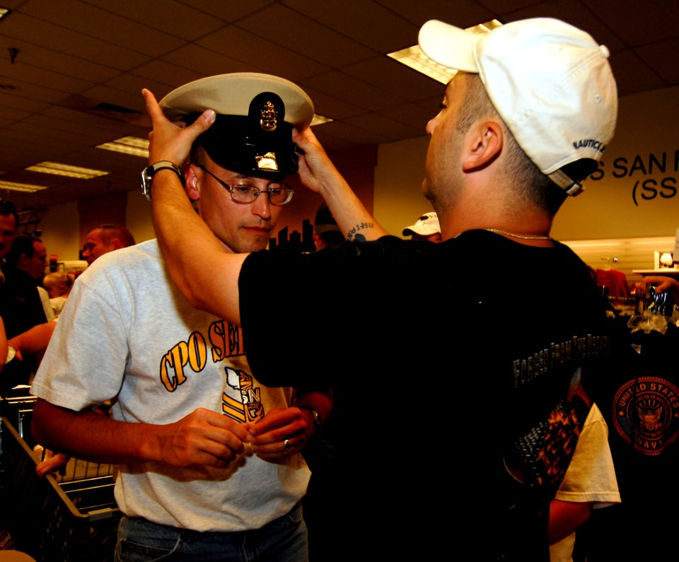 US Navy 090811-N-7780S-065 Chief Personnel Specialist (Sel) James McCormack leans forward while his sponsor, Chief Operations Specialist Larry Barlow, places a chief's cover on him