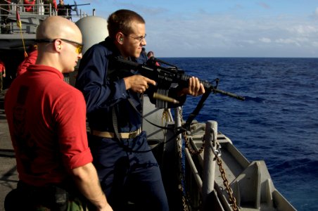 US Navy 090805-N-3038W-454 Gunner's Mate 2nd Class Jason Martin watches as Midshipman 3rd Class Gregory Kemper fires an M-16 service rifle during weapon familiarization aboard the aircraft carrier USS Nimitz (CVN 68)