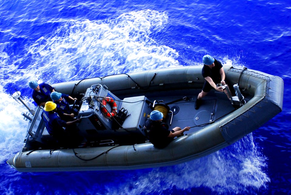 US Navy 090812-N-2918M-041 Rescue swimmers help steer a rigid hull inflatable boat after being lowered to the water during a drill aboard the aircraft carrier USS Nimitz (CVN 68)