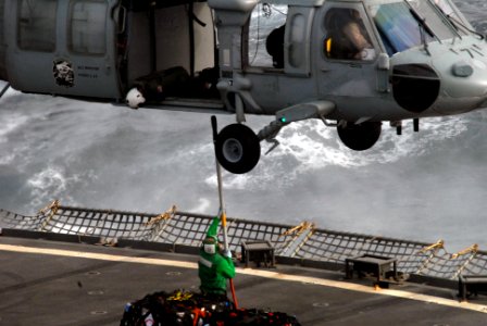 US Navy 090807-N-9132C-110 A crewmember assigned to the Military Sealift Command fast combat-support ship USNS Rainier (T-AOE 7) and an MH-60S Sea Hawk helicopter