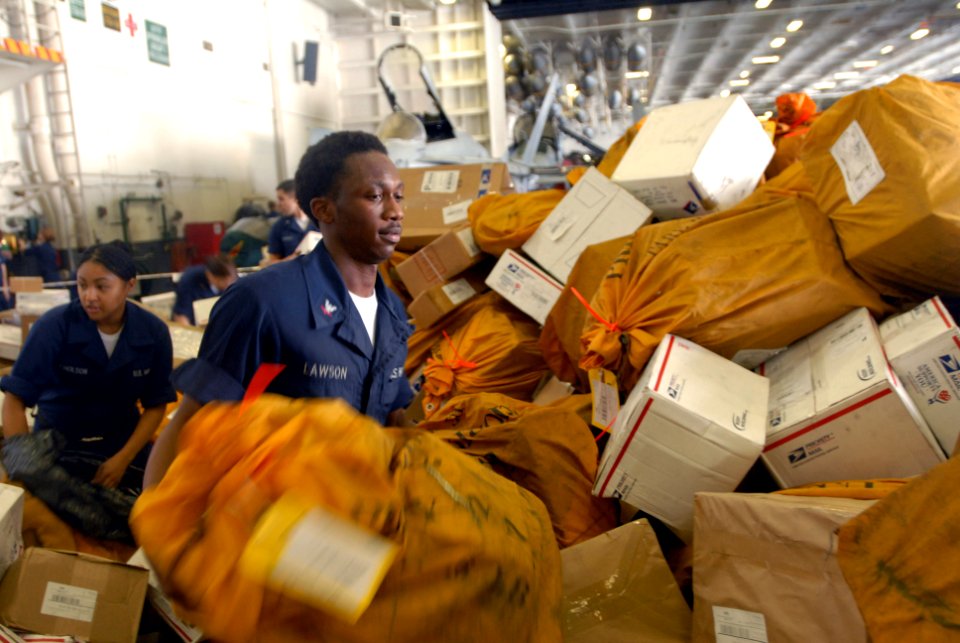 US Navy 090807-N-9132C-370 Information Systems Technician 3rd Class Calvin Lawson helps sort through 21,000 pounds of mail in the hangar bay of the aircraft carrier USS Ronald Reagan (CVN 76)