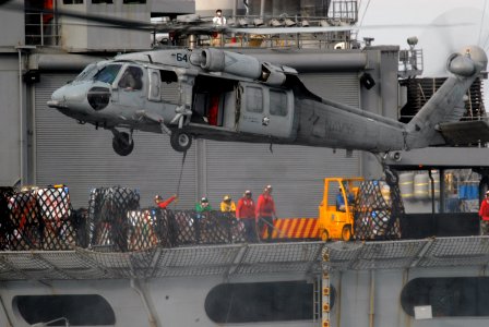 US Navy 090807-N-5586R-027 An MH-60S Sea Hawk helicopter assigned to the Blackjacks of Helicopter Sea Combat Squadron (HSC) 21 moves cargo from the Military Sealift Command fast combat-support ship USNS Rainier (T-AOE 7) during