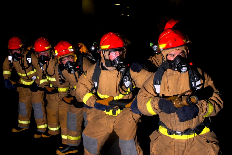 US Navy 090813-N-2600H-037 Hose team members fight a simulated fuel fire in the hangar bay aboard the aircraft carrier USS Nimitz (CVN 68)