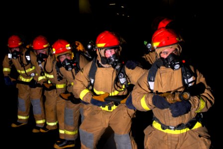 US Navy 090813-N-2600H-037 Hose team members fight a simulated fuel fire in the hangar bay aboard the aircraft carrier USS Nimitz (CVN 68)