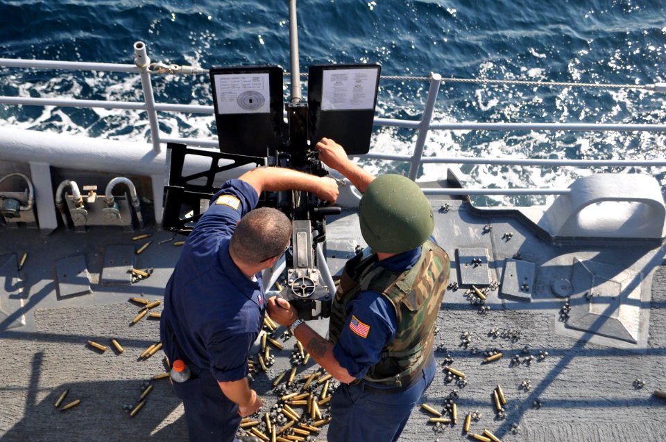 US Navy 090810-N-4124C-004 Gunners Mate 1st Class Todd Waldon and Fire Controllman 2nd Class Michael Sprague, both assigned to the guided-missile cruiser USS Normandy (CG 60), load a .50 caliber machine gun