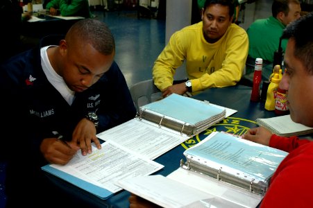 US Navy 090811-N-8960W-002 Quartermaster 1st Class Chauncey McWilliams fills out a Maintenance and Material Management form