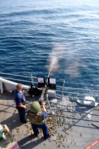 US Navy 090810-N-4124C-005 A member of the Ticonderoga-class guided-missile cruiser USS Normandy (CG 60), loads a .50 caliber machine gun during a crew served weapons live-fire exercise