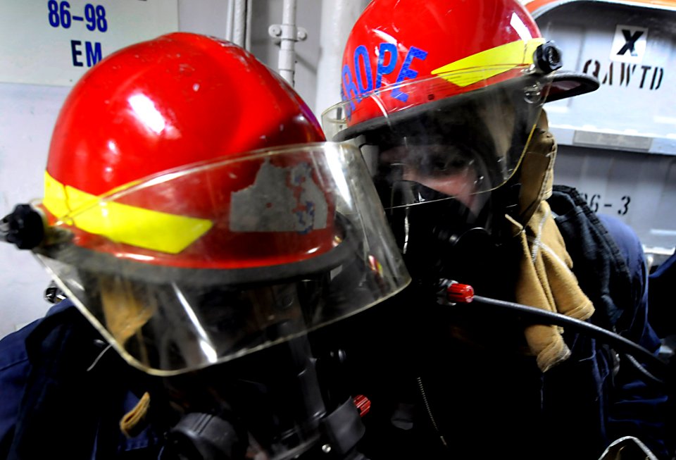 US Navy 090812-N-7280V-062 Hull Maintenance Technician 3rd Class Thomas Gibson relays a message to Information Systems Technician 3rd Class Jonetta McCoy that a simulated class-alpha fire is out during an underway drill