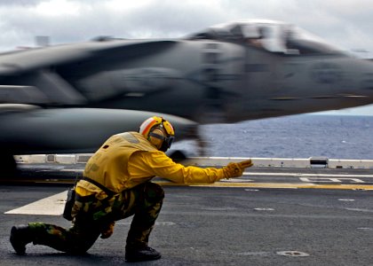 US Navy 090810-N-9950J-038 Aviation Boatswain's Mate (Handling) 1st Class Michael Quintos launches an AV-8B Harrier jet aircraft during the fly off of Marine Attack Squadron (VMA) 211, 31st Marine Expeditionary Unit (31st MEU)