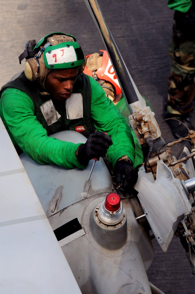 US Navy 090814-N-2344B-008 Aviation Machinist's Mate Airman James Fuller installs a tail gear box cowling on an SH-60F Sea Hawk helicopter assigned to the Black Knights of Helicopter Anti-Submarine Squadron (HS) 4 aboard the ai