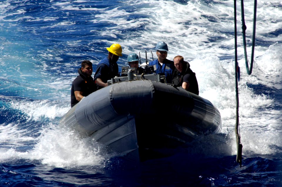 US Navy 090812-N-3038W-064 ailors in a rigid hull inflatable boat approach a boat davit to be raised back up to the ship during a drill aboard the aircraft carrier USS Nimitz (CVN 68)