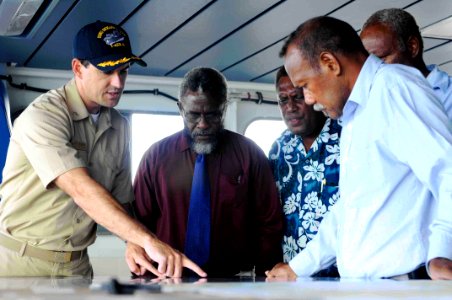 US Navy 090812-N-9689V-003 Capt. Jonathan Olmsted, ships master, of the Military Sealift Command dry cargo-ammunition ship USNS Richard E. Byrd (T-AKE 4) explains aspects of the ships bridge to the Premier of Malaita