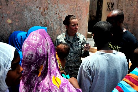 US Navy 090812-N-0506A-326 U.S. Air Force public affairs officer, interviews a family in front of their burned home in Djibouti photo