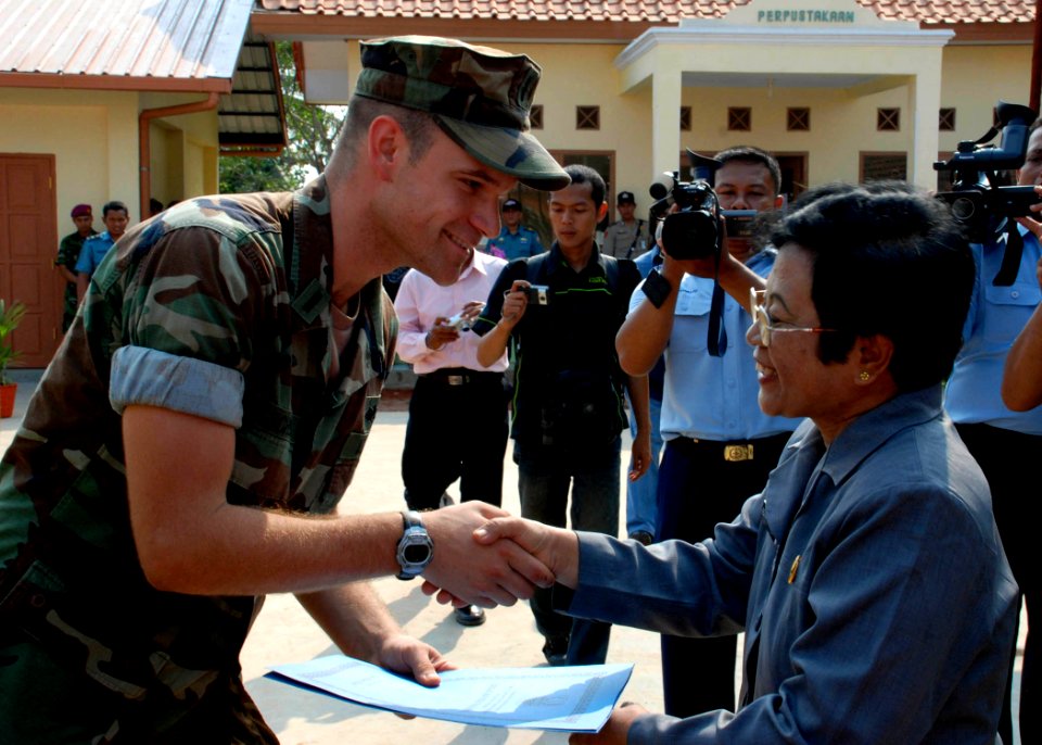 US Navy 090814-N-7095C-138 Lt. j.g. Phil Schuler, assigned to Naval Mobile Construction Battalion (NMCB) 40, is congratulated by a local official at the dedication of an engineering civic action program at Pusaka Rakyat primary