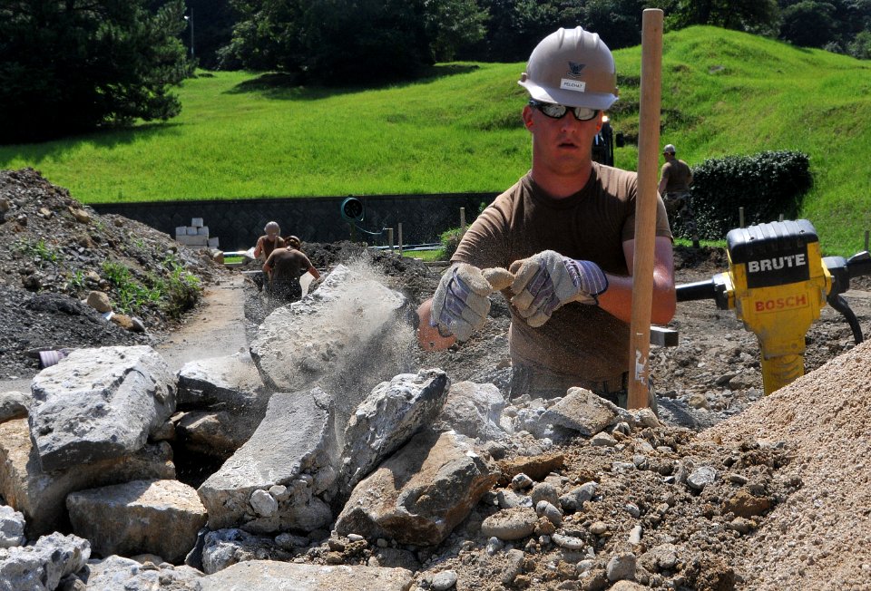 US Navy 090818-N-0807W-033 Steelworker 2nd Class Jean Luc Pelchat, from Montreal assigned to Naval Mobile Construction Battalion (NMCB) 1, breaks down rocks and removes debris