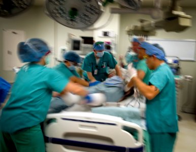 US Navy 090814-N-7090S-216 Medical staff at Brooke Army Medical Center in San Antonio, Texas, lift a patient from one bed to another after surgery to move him to the recovery room