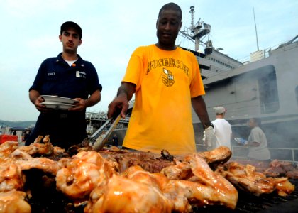 US Navy 090818-N-7478G-154 Chief (Select) Storekeeper Charles Mason mans the grill during a chief-select sponsored Hawaiian cookout